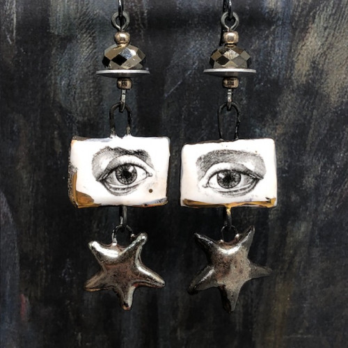 ongues boucles d'oreilles sont composées de deux pendentifs en céramique suspendus l'un à l'autre : le premier est carré et représente un oeil noir sur un fond blanc et or, le second est en forme d'étoile et bronze argenté.
