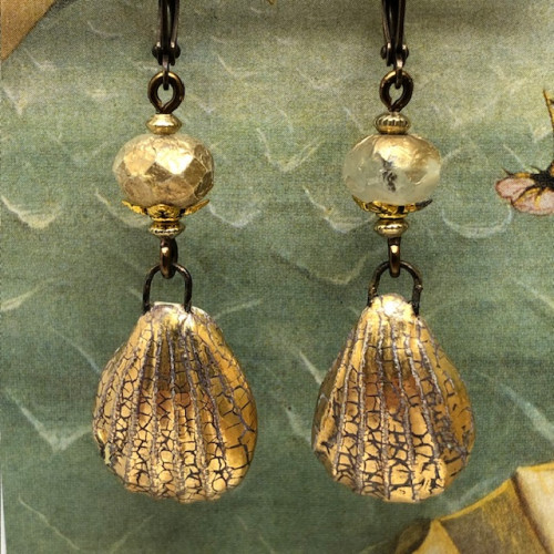 Boucles d’oreilles estivales composées de pendentifs en céramique en forme de coquillage et de perles en verre de Bohème dorés. Bijoux de créateur.