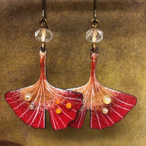 boucles d'oreilles asymétriques sont composées de superbes pendentifs en cuivre émaillé représentant une feuille de ginkgo biloba rouge orangé